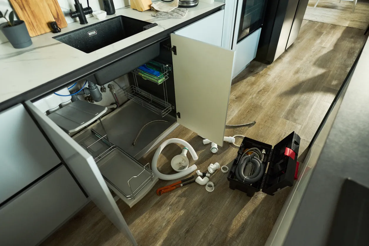 Plumber Repairing Kitchen Sink Pipe